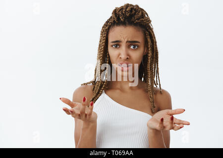 Frau Verwirrung nicht verstehen, was Freund anspielen auf. Portrait von clueless und befragt ahnungslos dunkelhäutige Frau mit dreads Gefühl Stockfoto