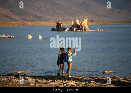 Zwei erwachsene Frauen fotografieren am Ufer des Mono Lake, Mono County, Kalifornien, USA Stockfoto
