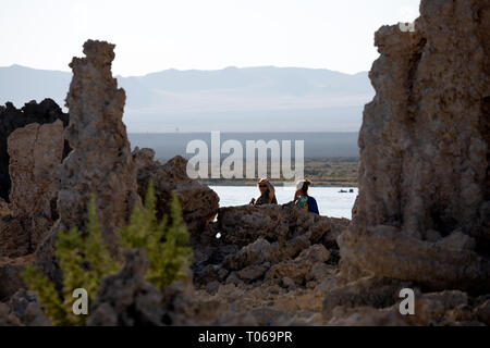 Zwei erwachsene Frauen, eine direkt in die Kamera schaut, zu Fuß durch die South Tufa Area, Mono Lake, Mono County, Kalifornien, USA Stockfoto