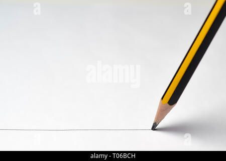 Bleistift malen eine Linie auf weißem Papier Stockfoto