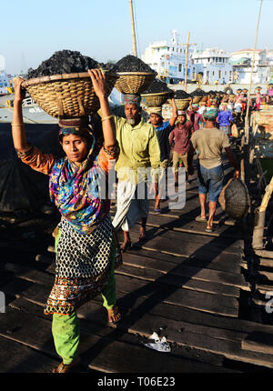 Bangladeshi arbeit Kohle, die ihre Köpfe von den Schiffen zu den Lastwagen. Stockfoto