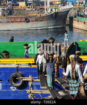 Bangladeshi arbeit Kohle, die ihre Köpfe von den Schiffen zu den Lastwagen. Stockfoto