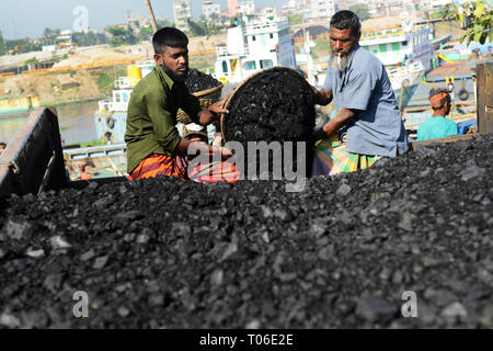 Bangladeshi arbeit Kohle, die ihre Köpfe von den Schiffen zu den Lastwagen. Stockfoto