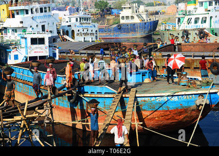 Bangladeshi arbeit Kohle, die ihre Köpfe von den Schiffen zu den Lastwagen. Stockfoto