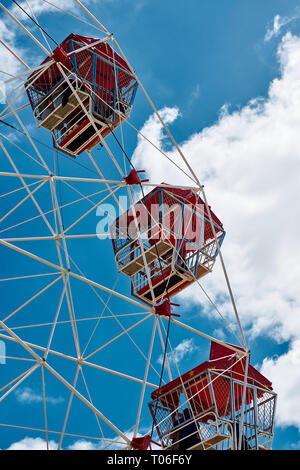 Nahaufnahme von drei rote Riesenrad Kapseln gegen eine lebendige Blauer Himmel und weiße Wolken. Stockfoto