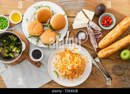 Hohe Betrachtungswinkel der Sommer Party Food Konzept. Vegetarische Burger mit verschiedenen Lebensmitteln. Vegetarische Kost ist nicht nur. Verschiedene Lebensmittel auf dem Tisch flach Stockfoto