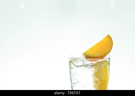 Ice Drink mit Orange und Eis im Studio auf einem weißen Hintergrund. Stockfoto