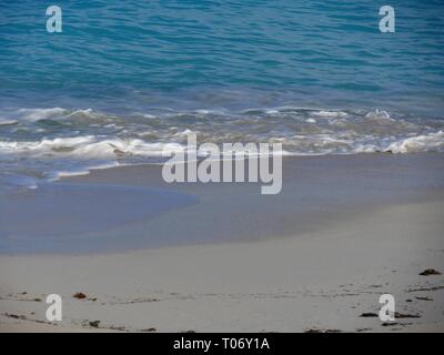 Sanfte Wellen brechen in der feinen, weißen Sandstrand in einem tropischen Strand Stockfoto