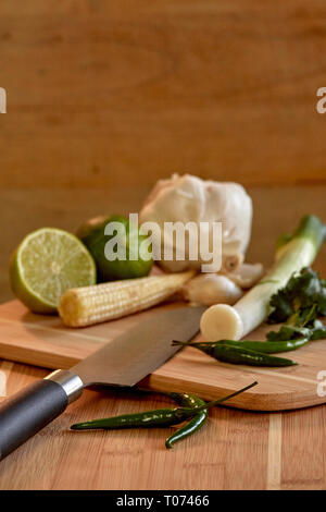 Asiatische Thai Chilis und Gemüse Zutaten auf Schneidebrett mit Santoku Messer Stockfoto