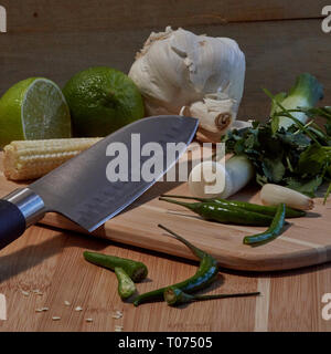 Asiatische Thai Chilis und Gemüse Zutaten auf Schneidebrett mit Santoku Messer Stockfoto