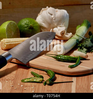 Asiatische Thai Chilis und Gemüse Zutaten auf Schneidebrett mit Santoku Messer Stockfoto