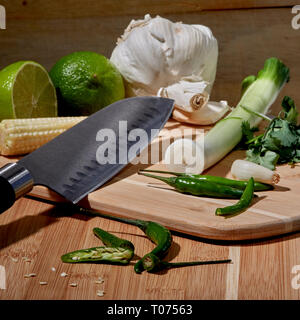 Asiatische Thai Chilis und Gemüse Zutaten auf Schneidebrett mit Santoku Messer Stockfoto