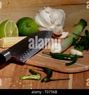 Asiatische Thai Chilis und Gemüse Zutaten auf Schneidebrett mit Santoku Messer Stockfoto