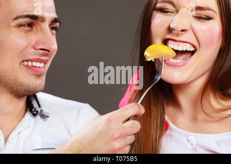 Lächelnd mann Fütterung glückliche Frau mit Apple. Frau und Mann das Essen von Früchten. Gesunde Ernährung, Diäten und Schlankheitskuren Konzept. Stockfoto