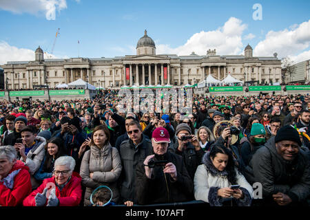 Menschen auf der Stufe auf dem Trafalgar Square suchen während der Parade. Die jährliche St. Patrick's Day Parade durch das Zentrum von London Hyde Park Corner zum Trafalgar Square. Stockfoto