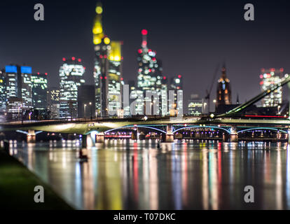 Dpatop - Die beleuchtete Skyline von Hochhaus Büro Gebäude stehen hoch über dem Floesserbruecke (C), der sich über den Main, Frankfurt, Deutschland, 20. Februar 2018. (Hinweis: Bild aufgenommen mit einem Tilt-shift Objektiv) Foto: Frank Rumpenhorst/dpa | Verwendung weltweit Stockfoto