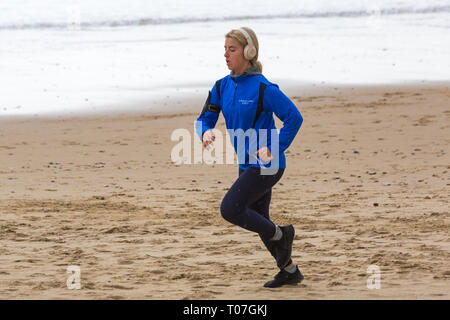 Bournemouth, Dorset, Großbritannien. 18 Mär, 2019. UK Wetter: Regen fallen auf Besucher in Bournemouth Strände. Junge Frau joggen entlang des Meeres im Regen nass zu werden. Credit: Carolyn Jenkins/Alamy leben Nachrichten Stockfoto