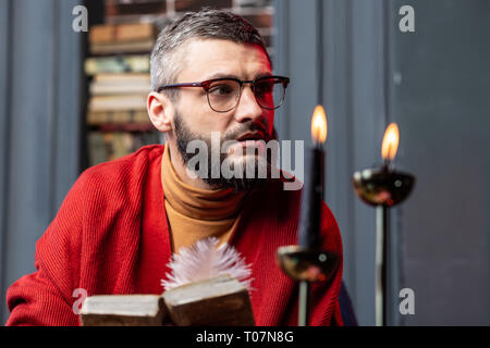 Bärtige Wahrsager Gefühl nachdenklich nach dem Lesen der alten Magier Buch Stockfoto