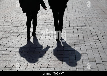 Silhouetten und Schatten der zwei Frauen auf der Straße. Konzept der streiten Mädchen, weibliche Freundschaft, emotionale Diskussion, Geste, Klatsch Stockfoto