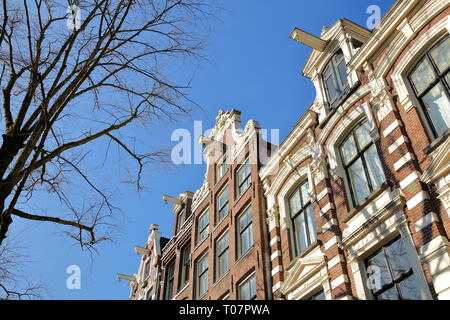 Krumm und farbenfrohe historische Gebäude, entlang Bloemgracht Kanal im Jordaan, Amsterdam, Niederlande Stockfoto