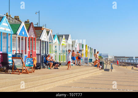 Southwold, UK - 11. September 2018 - die Menschen in der Sonne an der Promenade von Southwold Strand gesäumt mit einer Reihe von Strandhütten Stockfoto