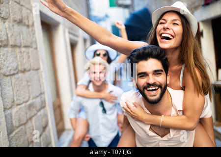 Gerne Freunde huckepack genießen, während die Sehenswürdigkeiten in der Stadt. Stockfoto