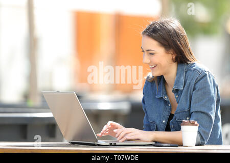 Frau mit einem Notebook Schreiben von e-Mails in eine Tabelle in einem Park Stockfoto