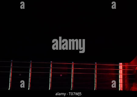 E-Gitarre Hals mit rotem Licht in dunklen Hintergrund beleuchtet (Foto ist glatt, nicht verpixelt, wie es in der Vorschau scheint). Stockfoto