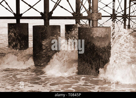 Wellen, die unter dem Pier in Cromer im Winter in Norfolk England England Stockfoto