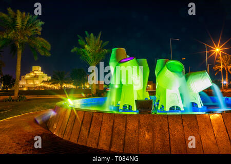 Doha, Katar - Februar 16, 2019: Wasser Töpfe Brunnen oder jar-Brunnen auf der Corniche mit Museum für Islamische Kunst und das Museum Park mit Palm Stockfoto