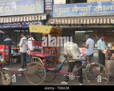 NEU-DELHI, INDIEN – 2018. MÄRZ: Nahaufnahme der Fahrer von Fahrrad-Rikschas warten auf Passagiere am frühen Morgen vor einem Restaurant am Straßenrand Stockfoto