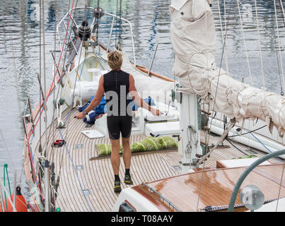 Sailor überspringen/Arbeiten auf großen Yachtcharter in Marina. Stockfoto