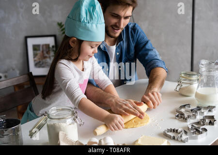 Vater und Tochter backen Gebäck. Familie Spaß in Küche und immer bereit für eine Party. Stockfoto