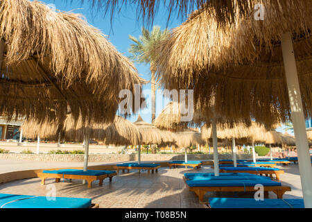 Liegestühle und Sonnenschirme auf Stroh Tropical Resort Stockfoto