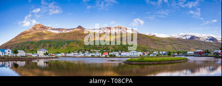 Panoramablick auf Seydisfjördur mit Häusern und die umliegende Landschaft in Fjardara See widerspiegeln. Seydisfjördur ist eine kleine malerische Stadt und Hafen Stockfoto