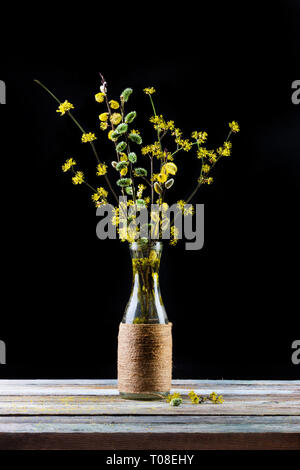 Blumenstrauß aus blühende Zweige der Weide und hartriegel in einer Vase auf dem Tisch auf schwarzem Hintergrund Stockfoto