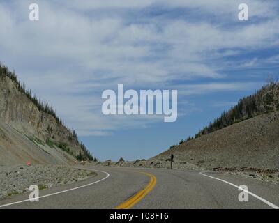 Landschaftlich reizvolle Fahrt auf einer asphaltierten Straße, die sich einer Straßenbaustelle im Yellowstone National Park nähert. Stockfoto