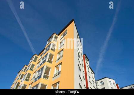 Hochhaus Gebäude auf mehreren Etagen. Blauer Himmel mit 2 weißen Linien aus einem Flugzeug. Stockfoto