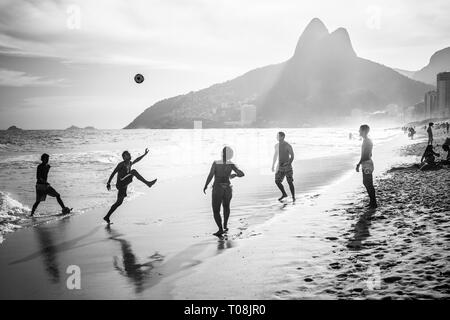 RIO DE JANEIRO, BRASILIEN - 24. FEBRUAR 2015: Eine Gruppe von Brasilianern spielen am Ufer des Ipanema Beach, mit dem berühmten Dois Irmaos Berg hinter Ihnen Stockfoto