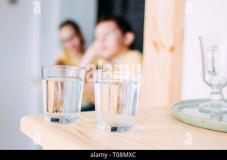 Zwei Gläser mit sauberem Wasser, Kinder im Hintergrund Stockfoto