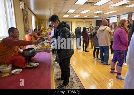 Anbeter in einem buddhistischen Tempel Form einer Montagelinie zu dienen Essen, besonders für ihre Mönche vorbereitet. In Elmhurst, Queens, New York City. Stockfoto