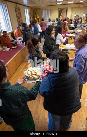 Anbeter in einem buddhistischen Tempel Form einer Montagelinie zu dienen Essen, besonders für ihre Mönche vorbereitet. In Elmhurst, Queens, New York City. Stockfoto