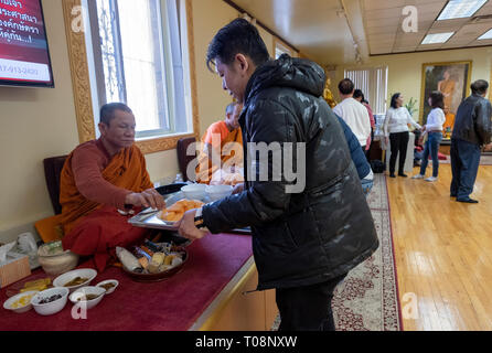 Anbeter in einem buddhistischen Tempel Form einer Montagelinie zu dienen Essen, besonders für ihre Mönche vorbereitet. In Elmhurst, Queens, New York City. Stockfoto