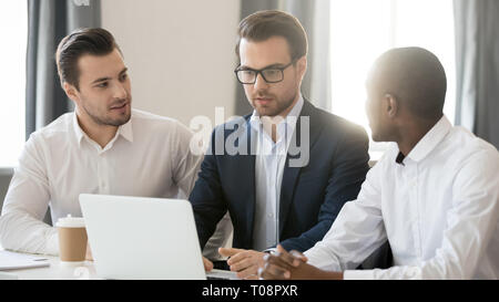 Drei verschiedene Unternehmer gemeinsam Zusammenarbeiten auf Laptop im Büro Stockfoto