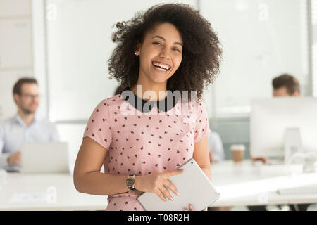 Gerne afrikanische Geschäftsfrau Holding digital Tablet an Kamera suchen Stockfoto