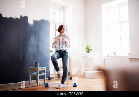 Ein Porträt der jungen Frau Malerei Wand schwarz. Ein Anlauf von kleinen Unternehmen. Stockfoto