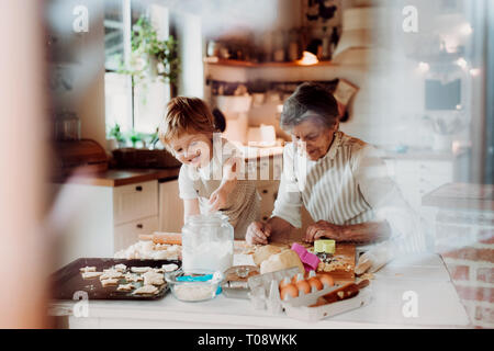 Senior Großmutter mit kleinen Toddler boy Kuchen zu Hause. Stockfoto