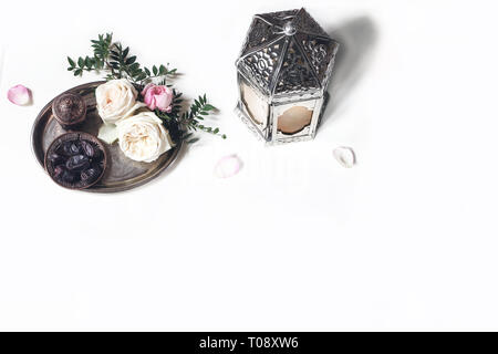 Gruß Ramadan Kareem Karte, Einladung. Silber Laterne, Termine Obst, Bronze kaffeetasse, Rosen, Blumen, grünen Zweige auf alte Fach. weißer Tisch hinterg Stockfoto