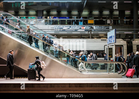 Berlin, Deutschland - März 2019: Personen mit Gepäck auf der Rolltreppe im Bahnhof (Hauptbahnhof) in Berlin, Deutschland Stockfoto