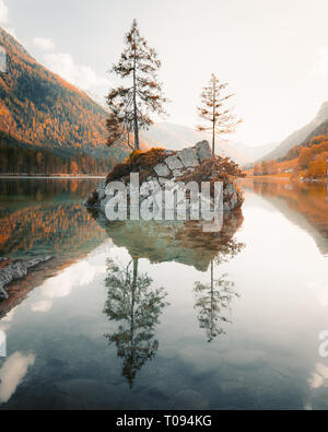 Schöner Blick auf die Bäume auf der Insel in die idyllische Landschaft am See Hintersee bei Sonnenuntergang, Berchtesgaden, Bayern, Deutschland Stockfoto